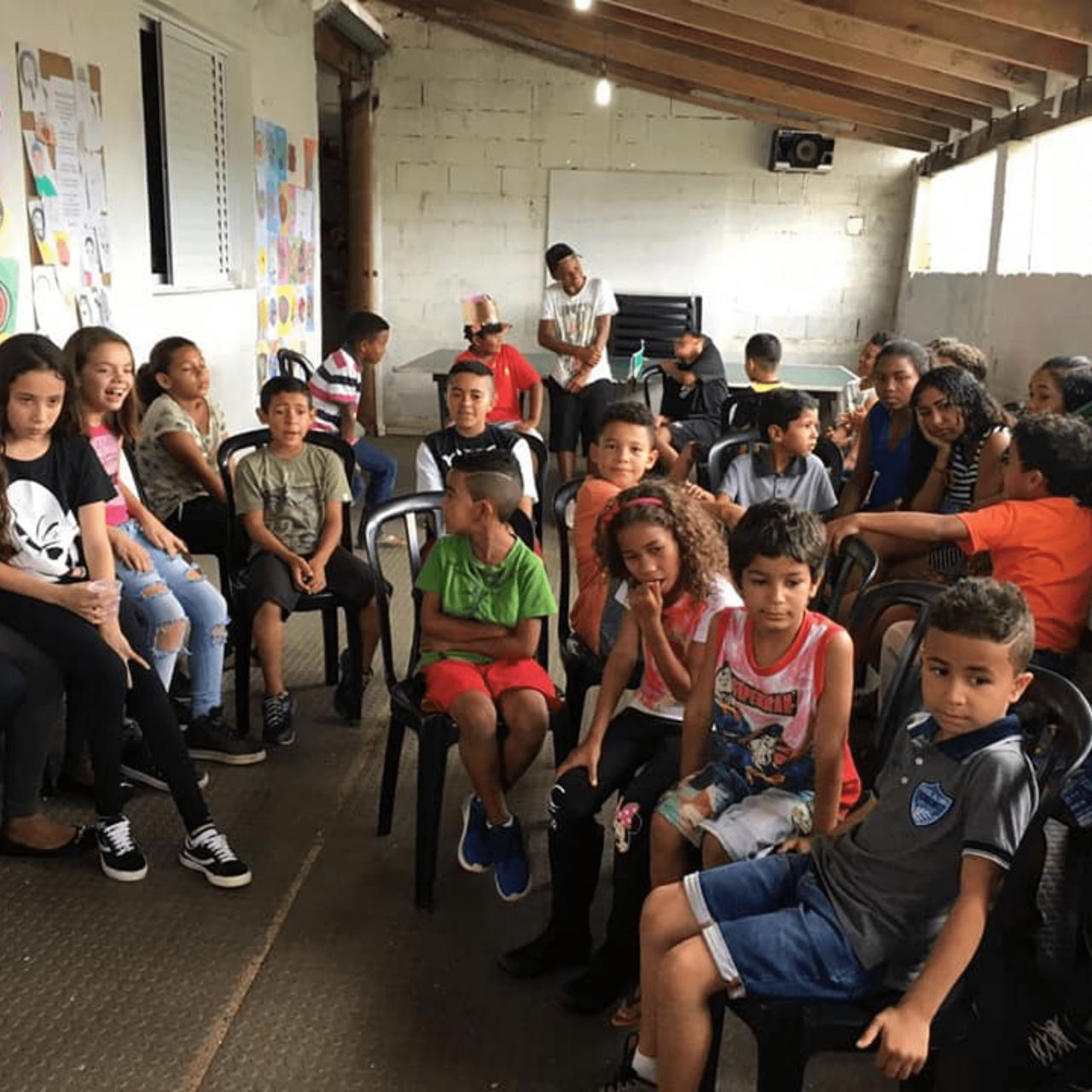 Crianças sentadas prestando atenção nos Amigos da Mortadela