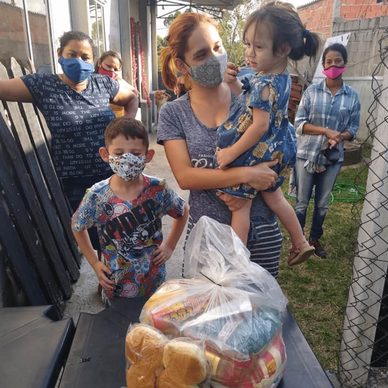 Família recebendo doação de alimentos